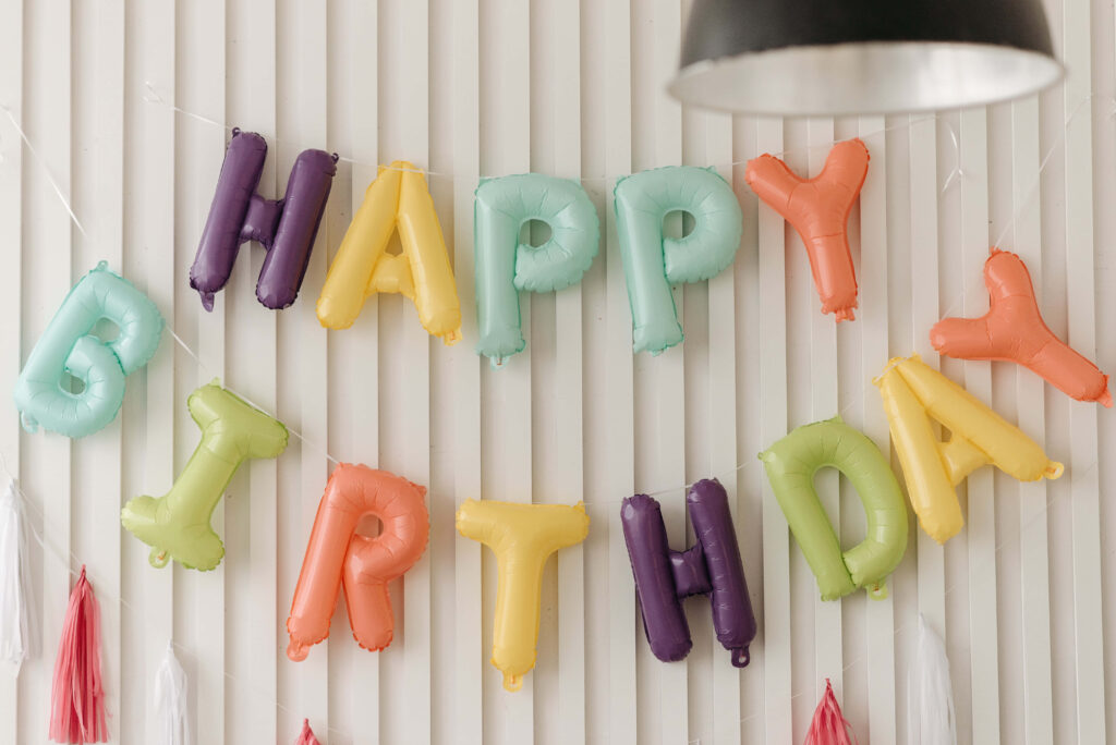 Festive Happy Birthday Balloon Letters Against Striped Wall Background Wallpaper