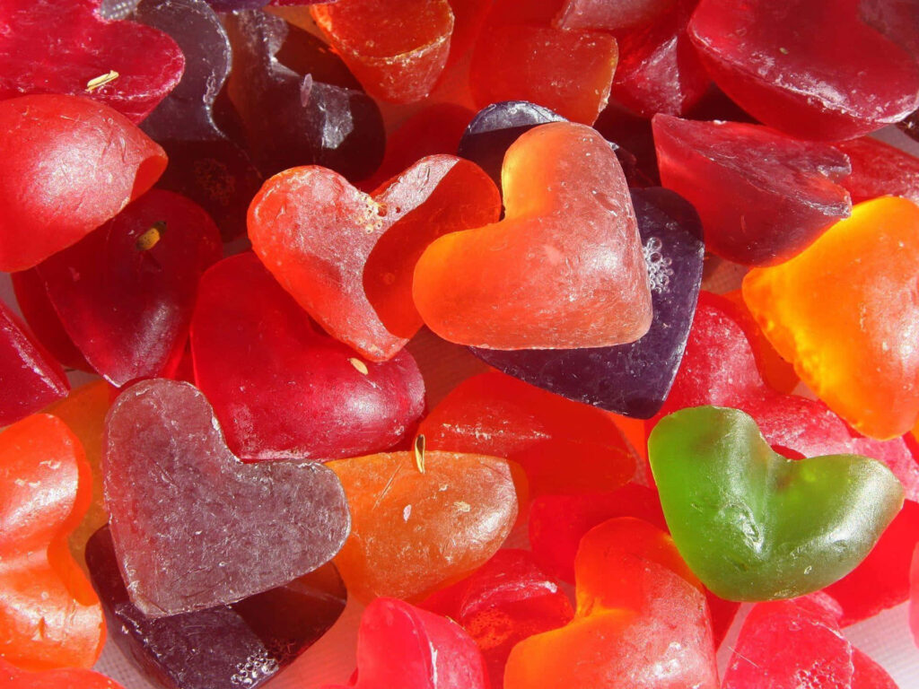 Vibrant Heart-Shaped Candy Wallpaper: Glossy & Colorful Background