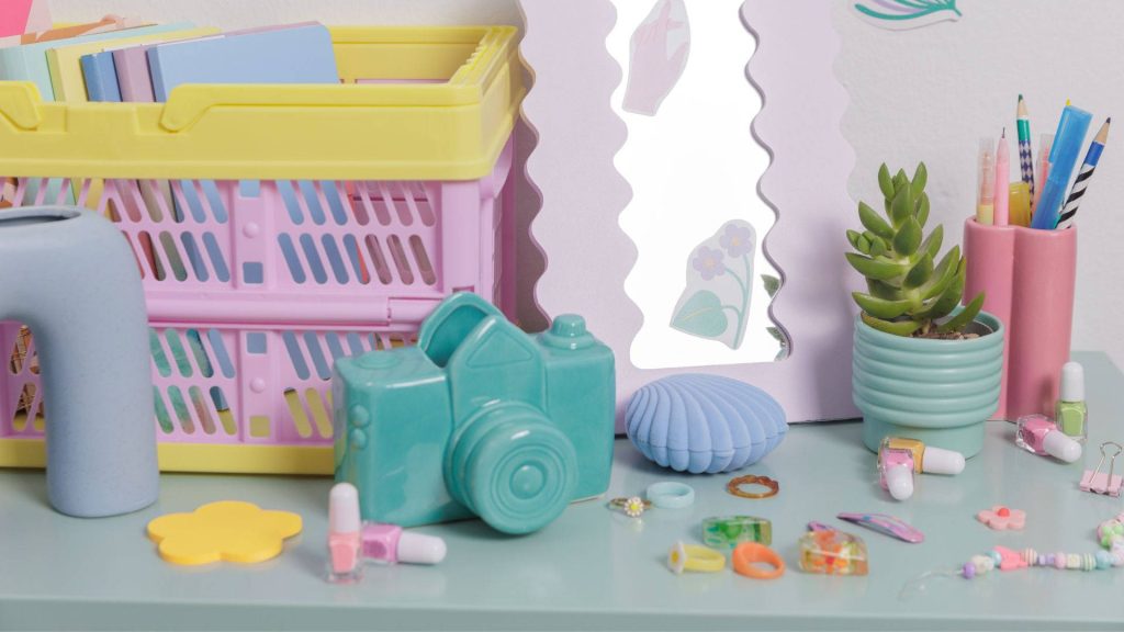 Colorful Kidcore aesthetic desk with teal camera succulent wavy mirror and pastel accessories Wallpaper