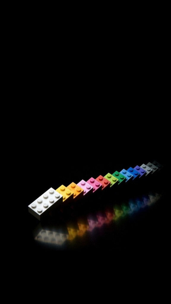 Colorful Lego bricks arranged in a gradient row on black minimalist wallpaper background