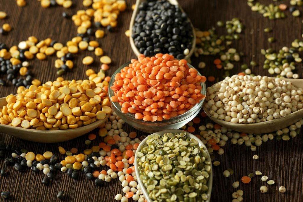 Colorful Lentils Wallpaper: Vibrant Bowls and Spoons on Dark Background