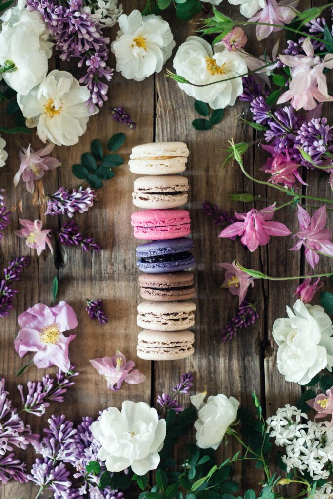 Colorful Macarons Surrounded by Flowers - Rustic Wallpaper Background