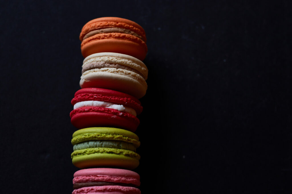 Colorful Macarons Wallpaper: Vibrant Delights on Dark Background