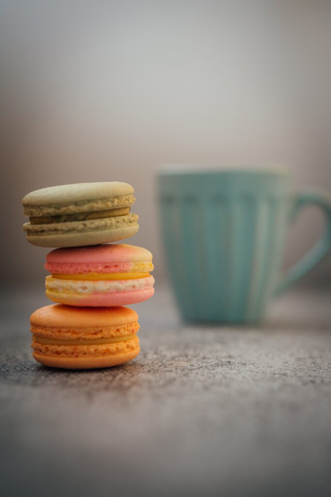 Colorful Macarons Wallpaper: Charming Background with Blue Cup Blur