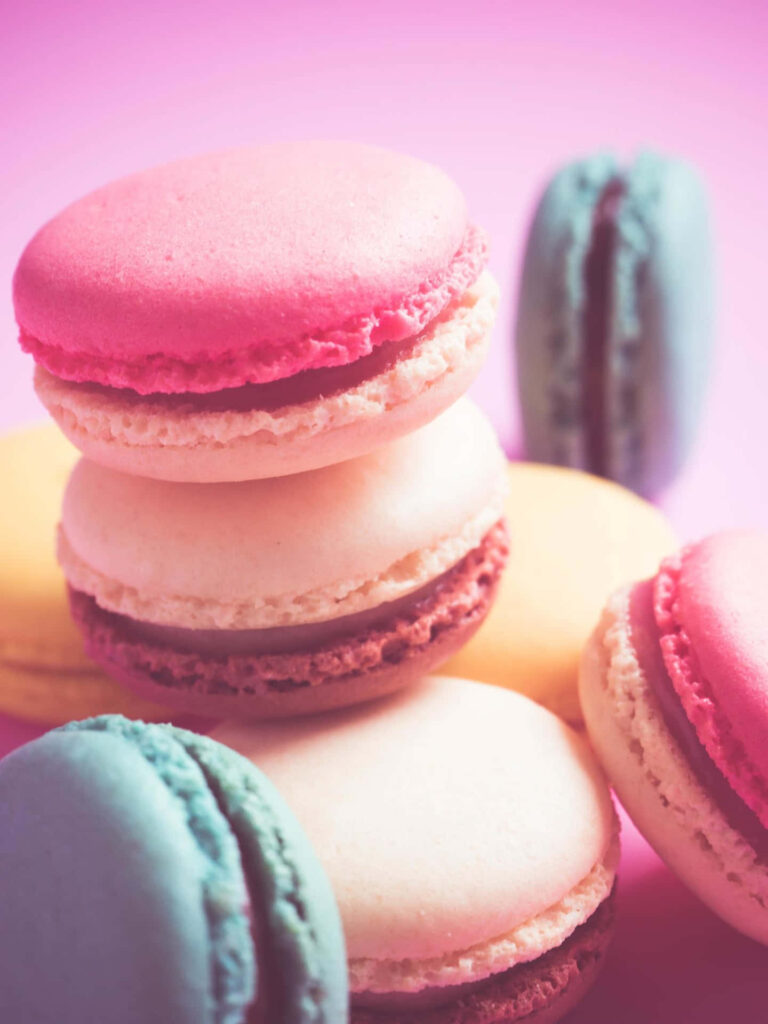 Colorful Macaroon Wallpaper: Yummy Treats on Soft Pink Background