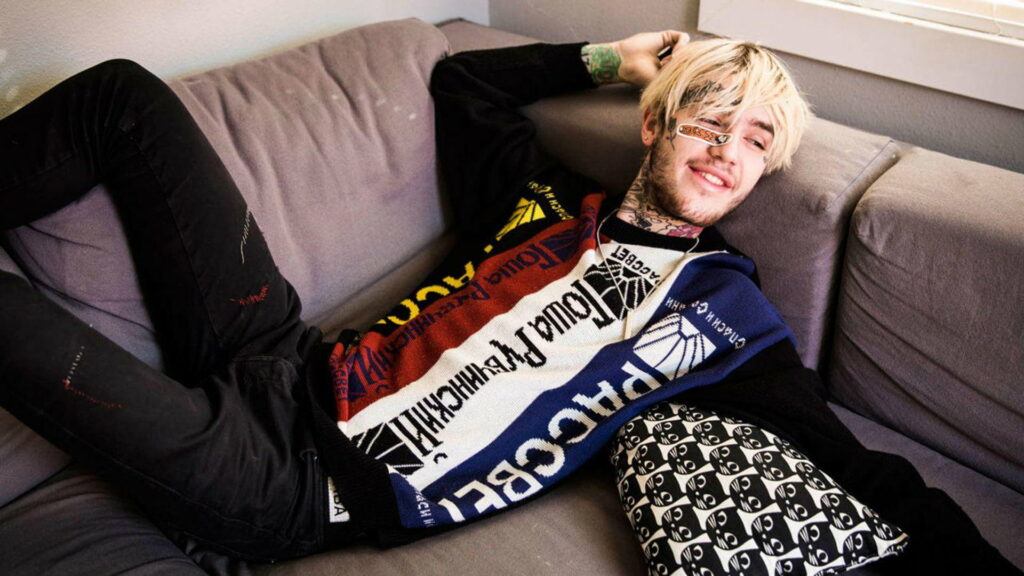 Colorfully Inked Lil Peep Relaxing on a Musical Couch Wallpaper