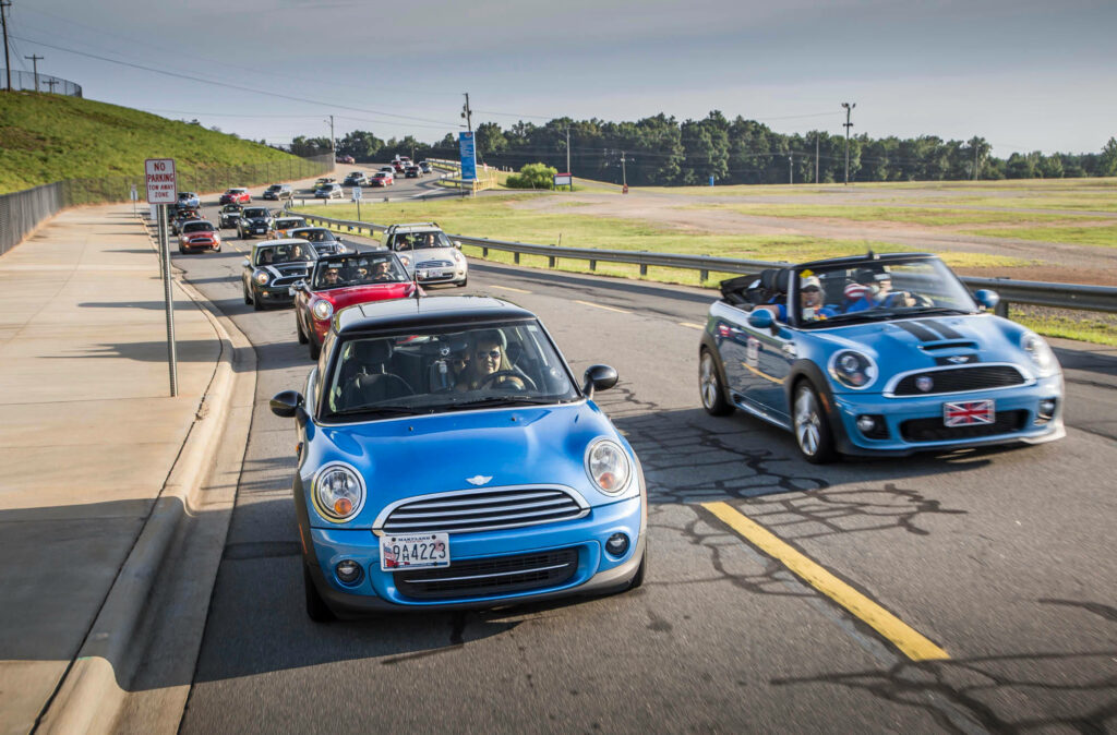 Colorful Mini cars parade along scenic road vibrant fun adventure dynamic wallpaper background