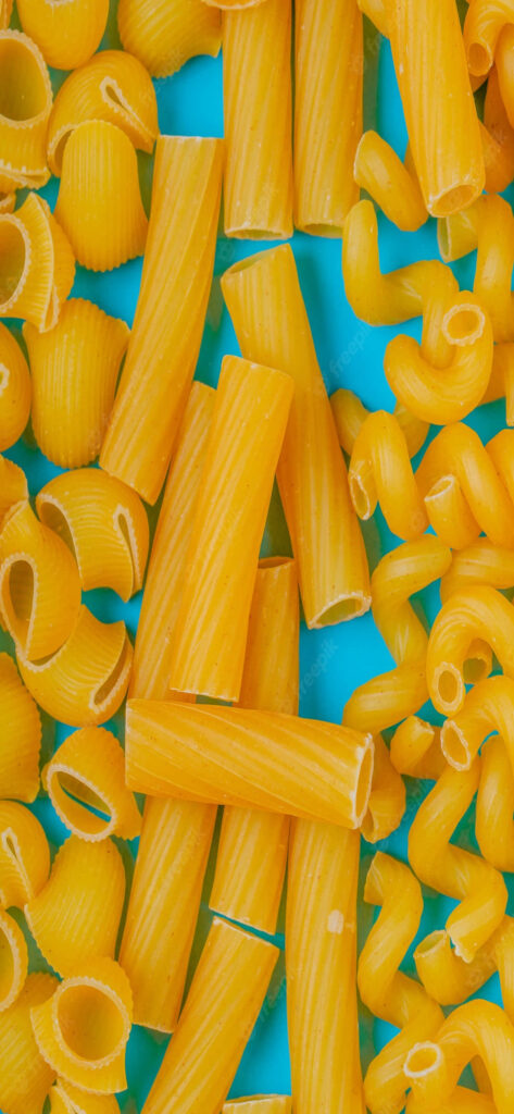 Colorful Pasta Shapes on Bright Blue Table - Vibrant Wallpaper Background
