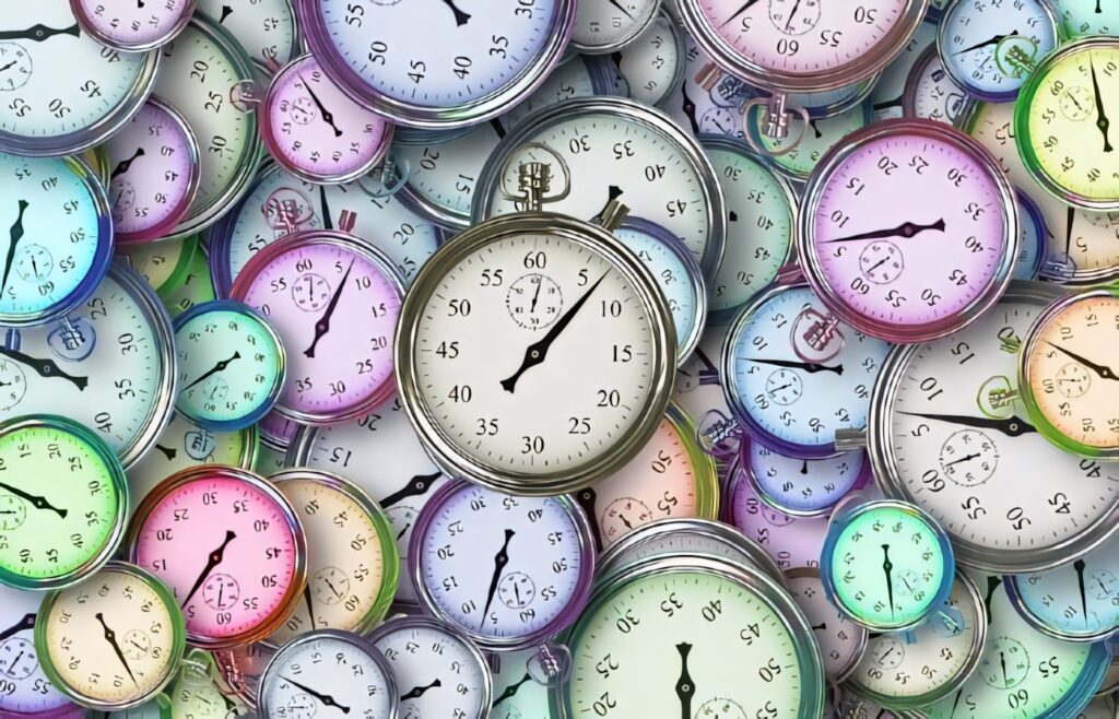 Colorful pastel watches and clocks piled in a dynamic vibrant wallpaper background design