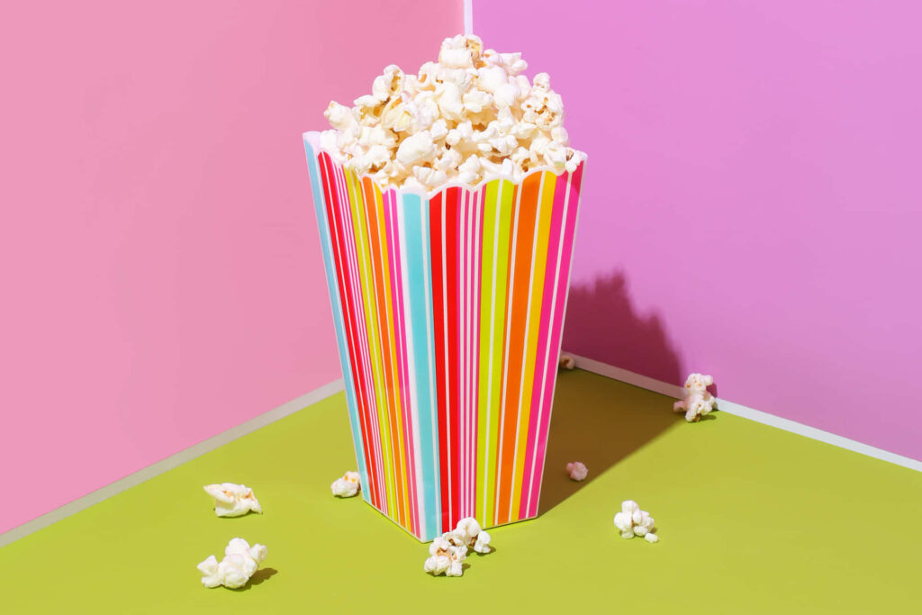 Vibrant Wallpaper: Colorful Popcorn Container on Pink & Green Background