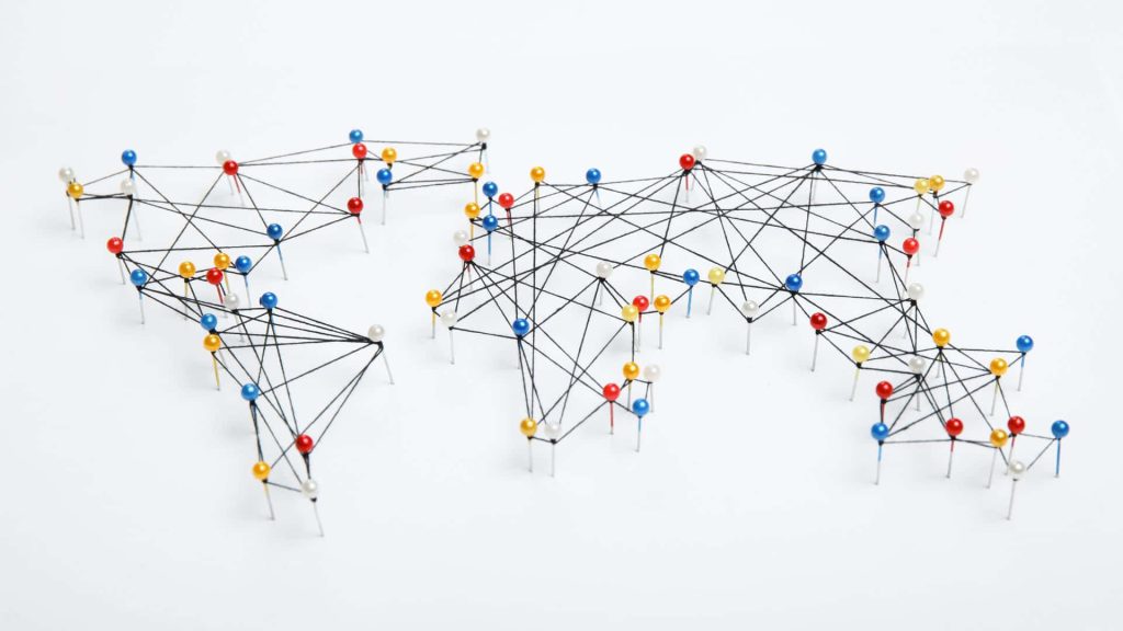 World map with red blue yellow pushpins linked by black thread on white background concept network Wallpaper