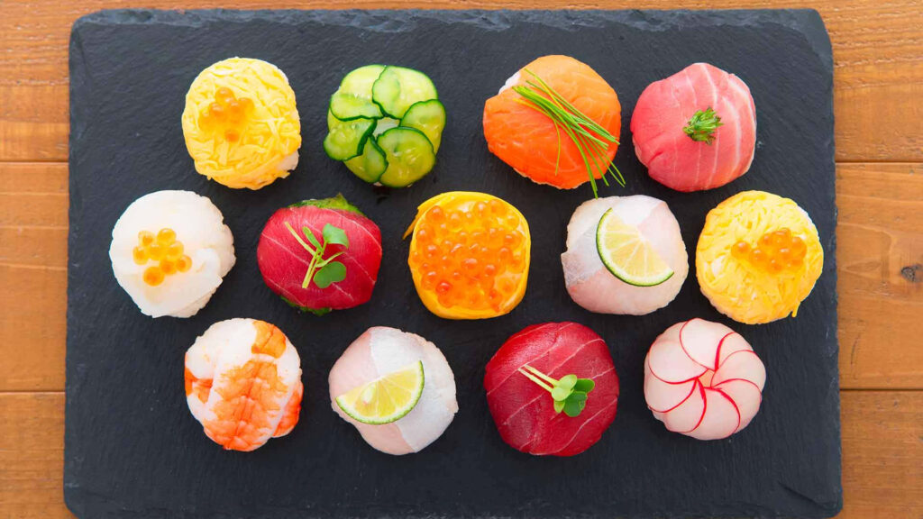Vibrant Sushi Balls with Salmon, Tuna & Shrimp on Slate Wallpaper