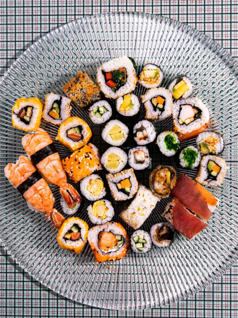 Vibrant Sushi Roll Assortment on Textured Glass Wallpaper Background