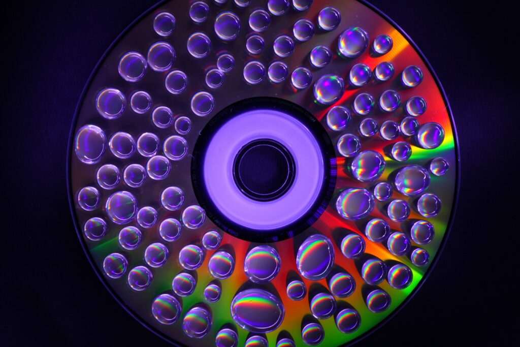Vibrant CD Wallpaper: Glowing Water Droplets & Rainbow Hues