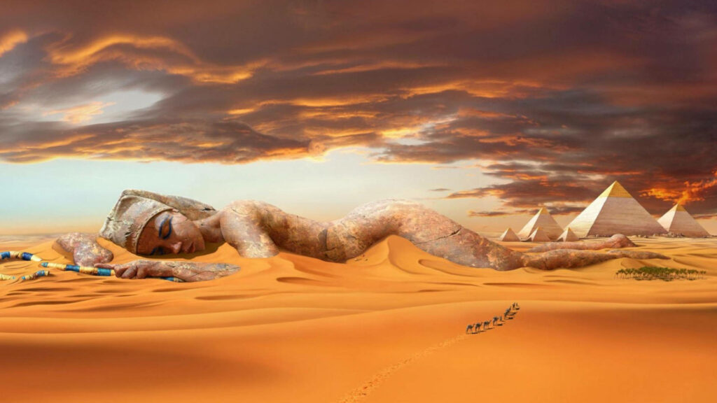 Colossal Cleopatra statue in golden desert sand with pyramids under dramatic sunset sky wallpaper