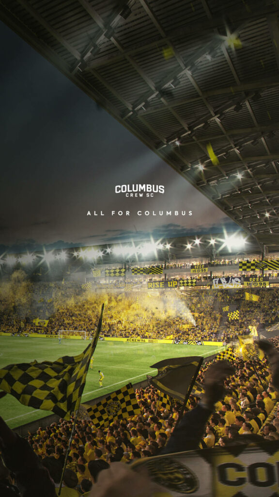 Columbus Crew fans in yellow shirts waving checkered flags in packed stadium vibrant wallpaper background