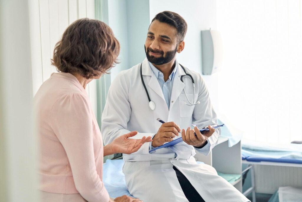 Compassionate doctor consulting patient in bright modern medical office showing trust care professionalism Wallpaper