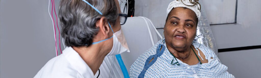 Compassionate masked doctor with glasses listens to patient in calm hospital room showing care Wallpaper