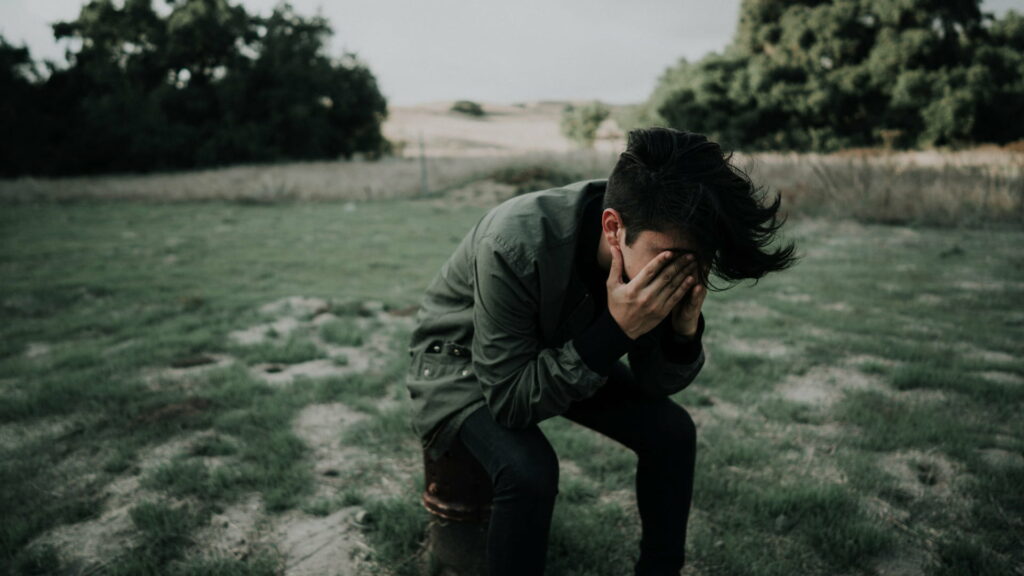 Concealed Agony: HD Wallpaper of a Despondent Boy Covering His Eyes with Hands
