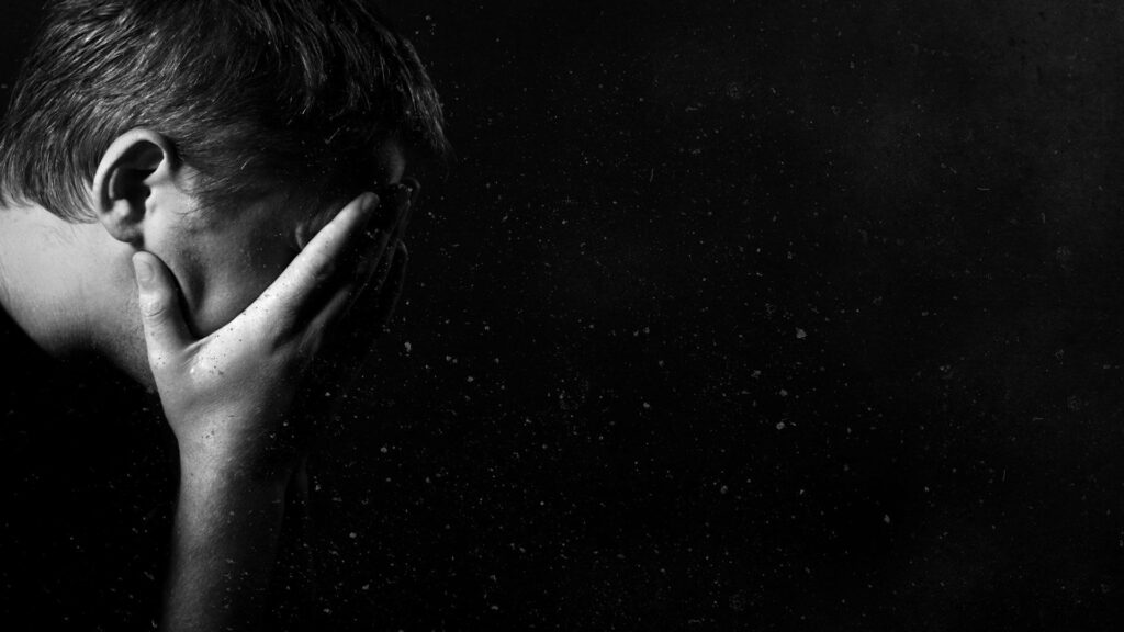 An HD Wallpaper of a Sorrowful Man Concealing his Face in Depression