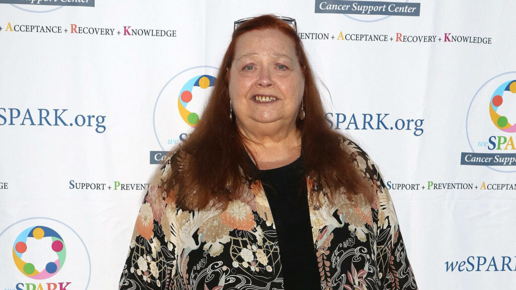 Conchata Ferrell smiles warmly in floral jacket at WeSpark Comedy Night cancer support event backdrop Wallpaper
