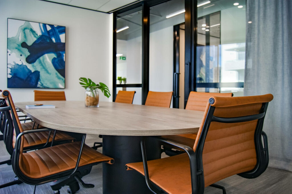 Modern bright conference room with wood table brown leather chairs abstract blue art plant Wallpaper