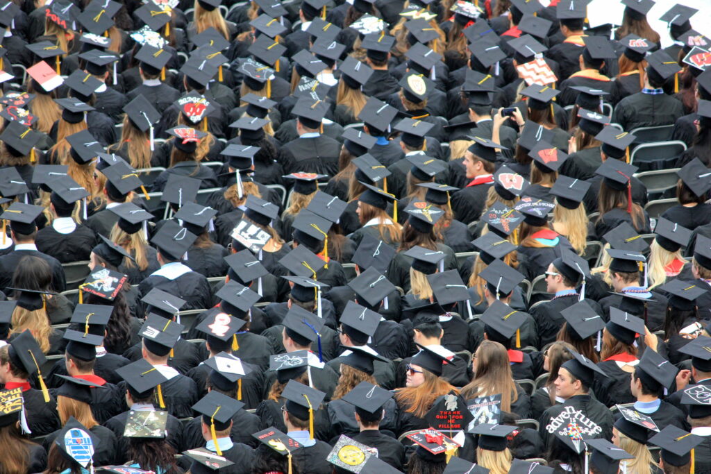 Aerial view of University of Wisconsin-Madison graduates in black robes and decorated caps celebration Wallpaper