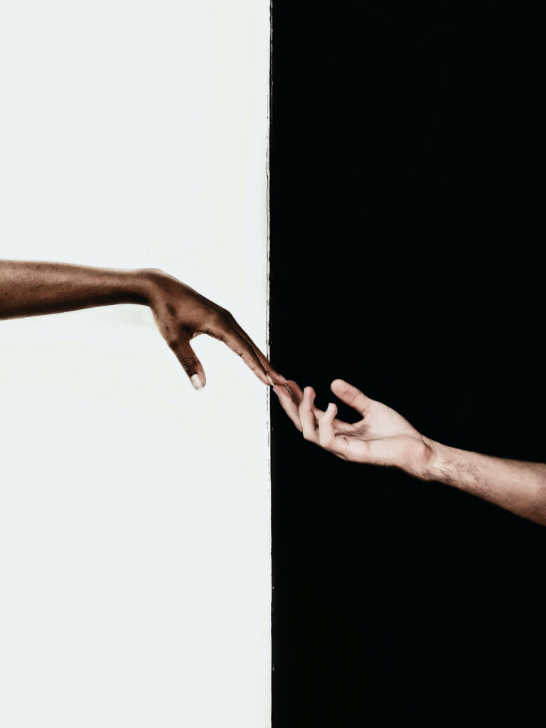 Two Hands Reaching: A Bold Black-and-White Connection Wallpaper