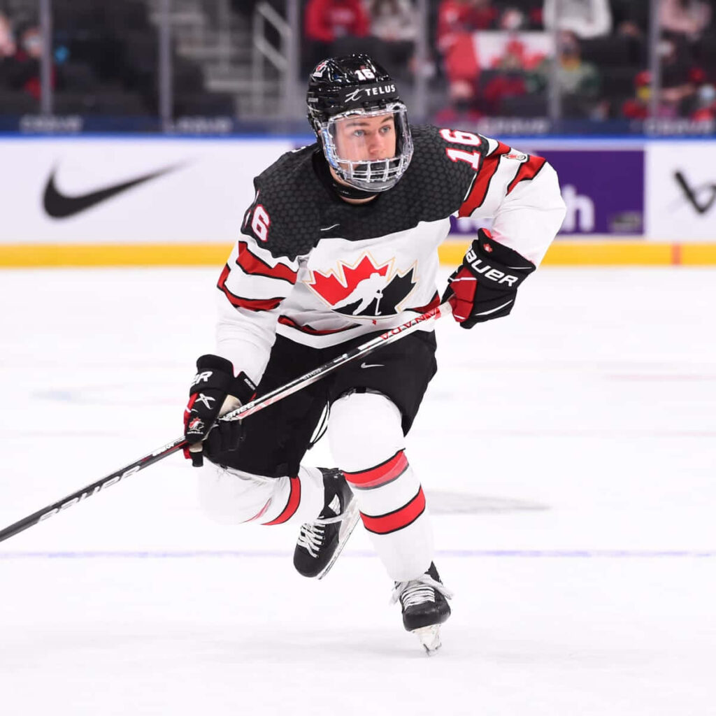 Connor Bedard in Canadian hockey jersey skating fast with intense focus on ice rink background Wallpaper