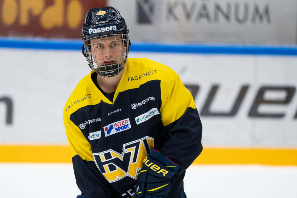Connor Bedard in yellow black hockey uniform skating on ice rink intense game action wallpaper