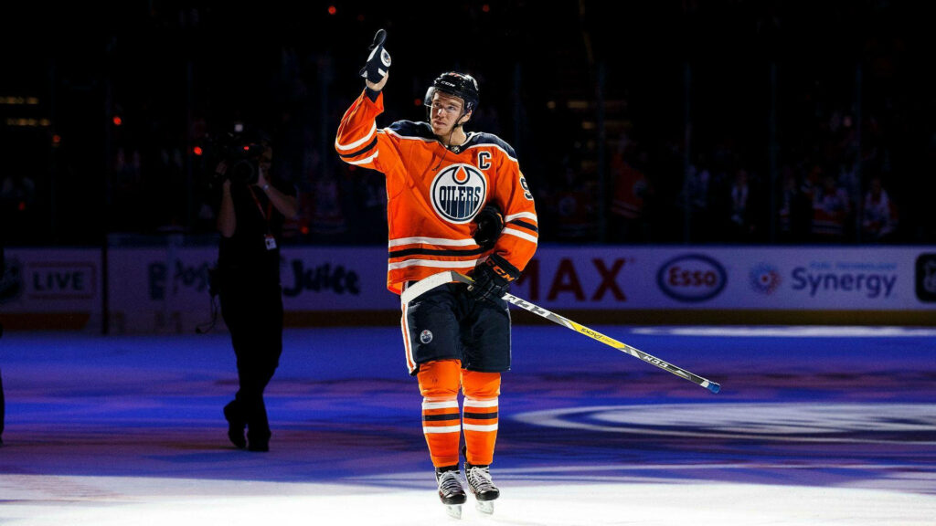 Connor McDavid Edmonton Oilers in orange jersey on ice with vivid colors and dramatic lighting Wallpaper
