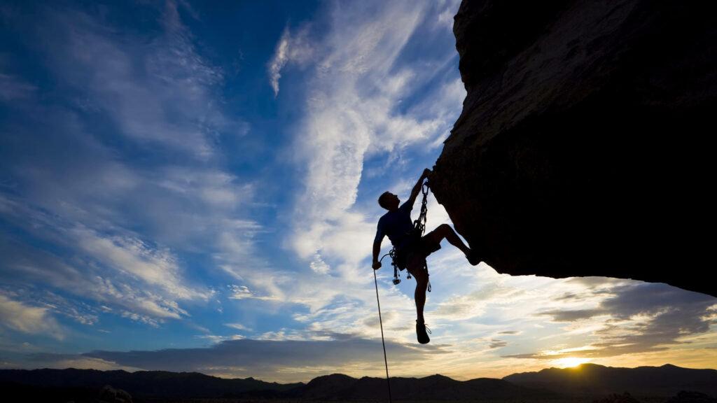Conquering Shadows: A Breathtaking Sunset Ascent Wallpaper