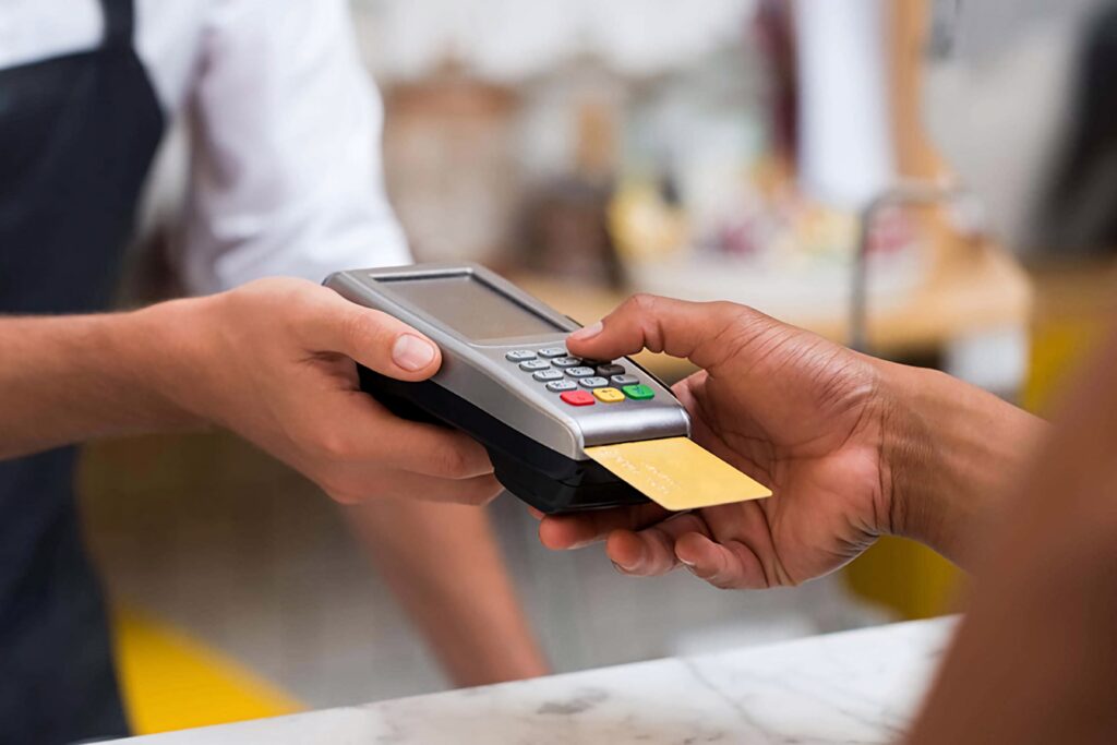 Man making contactless payment with credit card at cafe using modern payment terminal close-up Wallpaper
