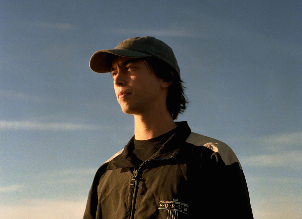 Contemplative Alex G reflecting at sunset with calm sky serene wallpaper background for fans