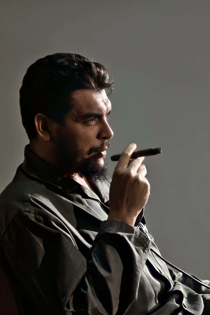 Che Guevara thoughtful pose holding cigar iconic revolutionary figure wallpaper background