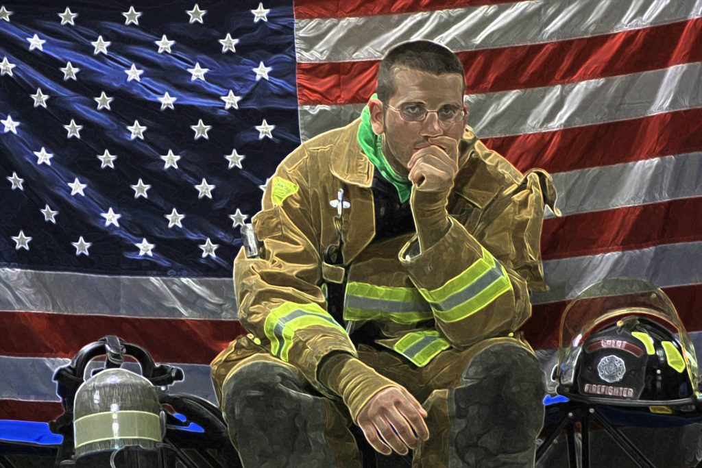 Contemplative firefighter in turnout gear sitting before USA flag patriotic wallpaper background