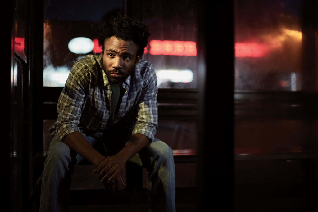 Contemplative Man at Night: Bus Stop Wallpaper with Neon Glow