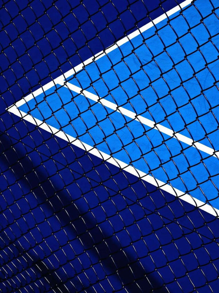 Serene Court Reflection: A Captivating Tennis Fence Close-Up on Ios Default Background Wallpaper