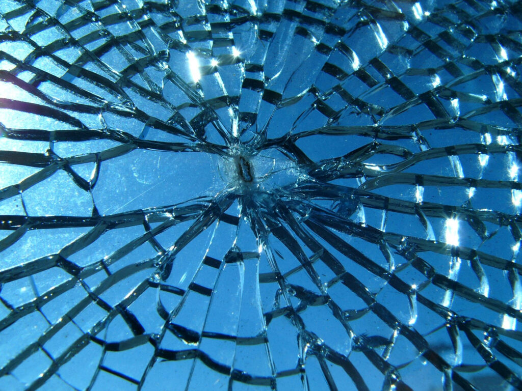HD broken screen wallpaper with detailed shattered glass cracks on vibrant blue background
