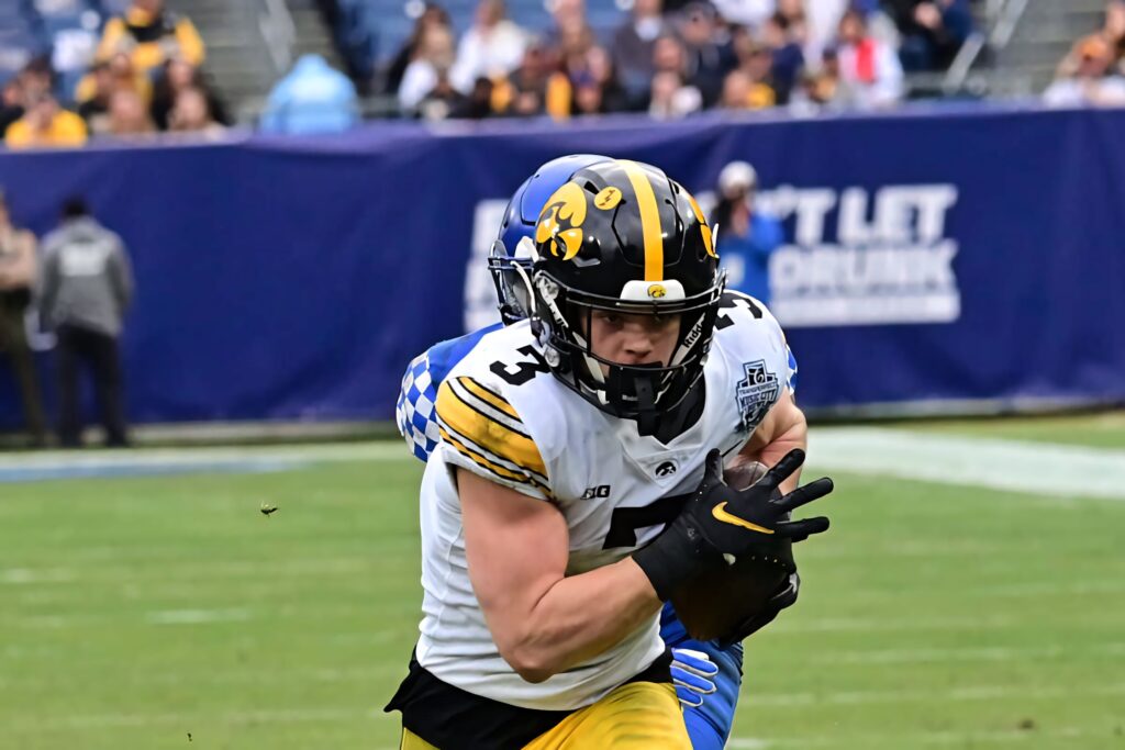 Cooper DeJean Iowa Hawkeyes action football wallpaper vibrant team colors stadium background
