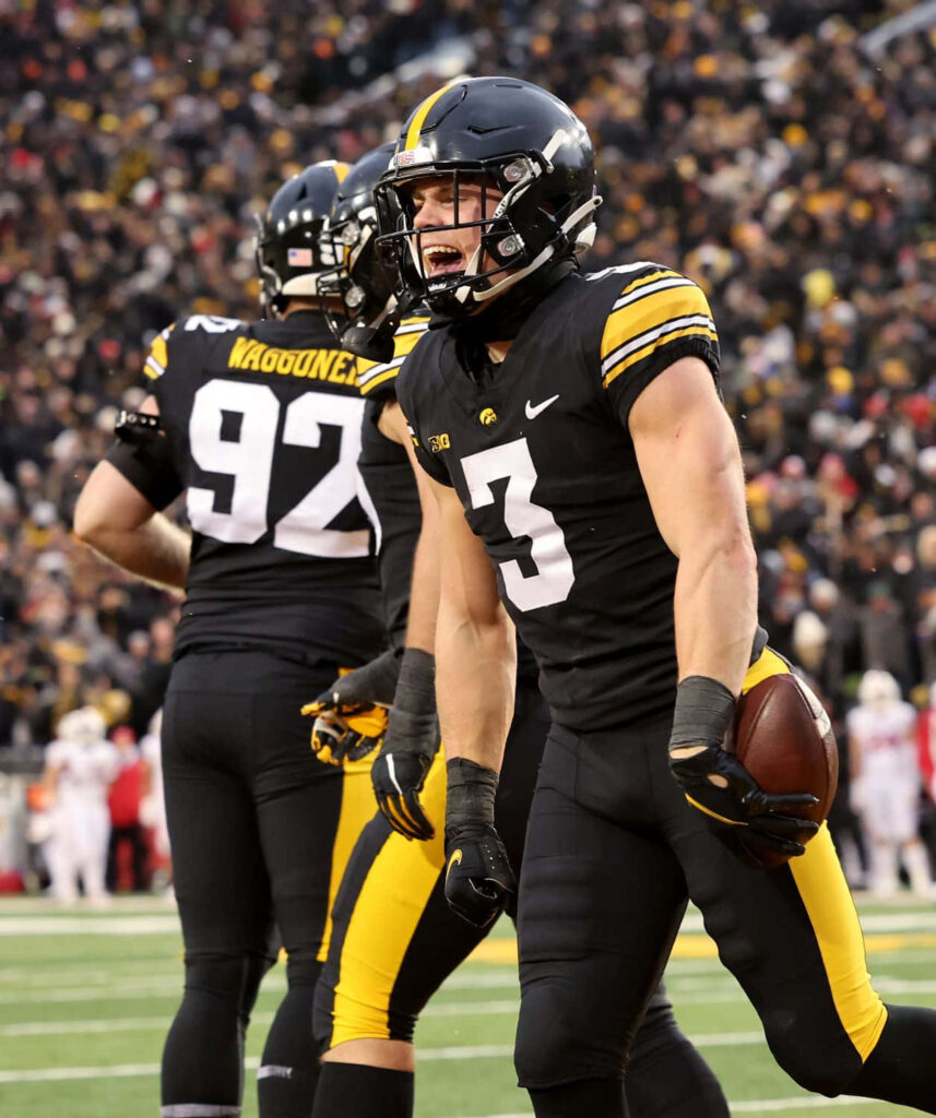 Cooper DeJean Iowa Hawkeyes defensive back in action intense football moment stadium background Wallpaper