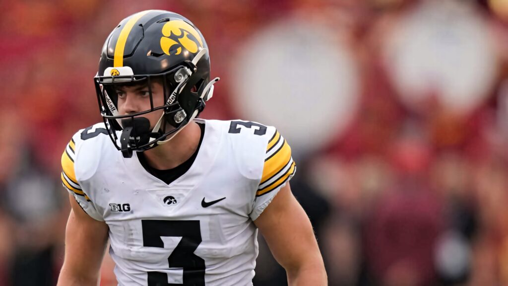 Cooper DeJean in Iowa Hawkeyes uniform showing focus and athleticism in football action shot Wallpaper