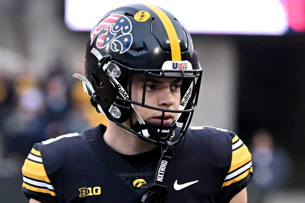 Cooper DeJean in Iowa Hawkeyes black and gold uniform focused on field football wallpaper background