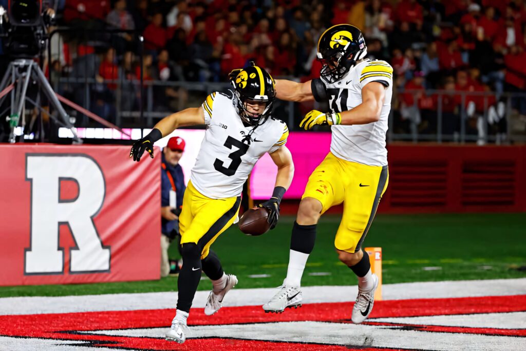 Cooper DeJean Iowa Hawkeyes touchdown celebration vibrant football action wallpaper background