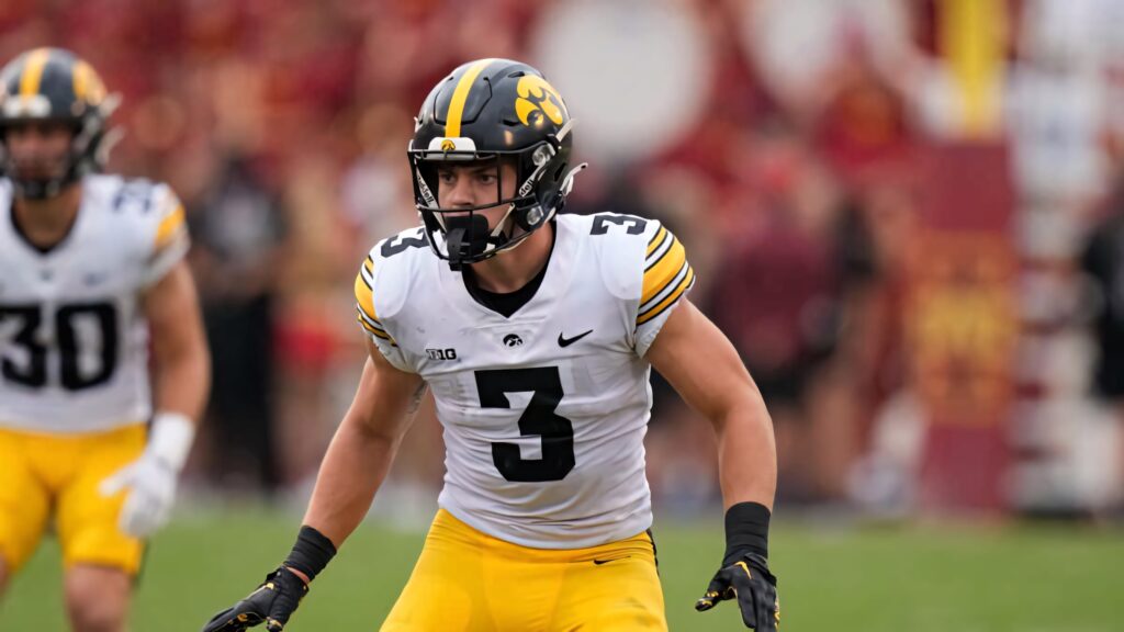 Cooper DeJean Iowa Hawkeyes defensive stance football wallpaper vibrant stadium background