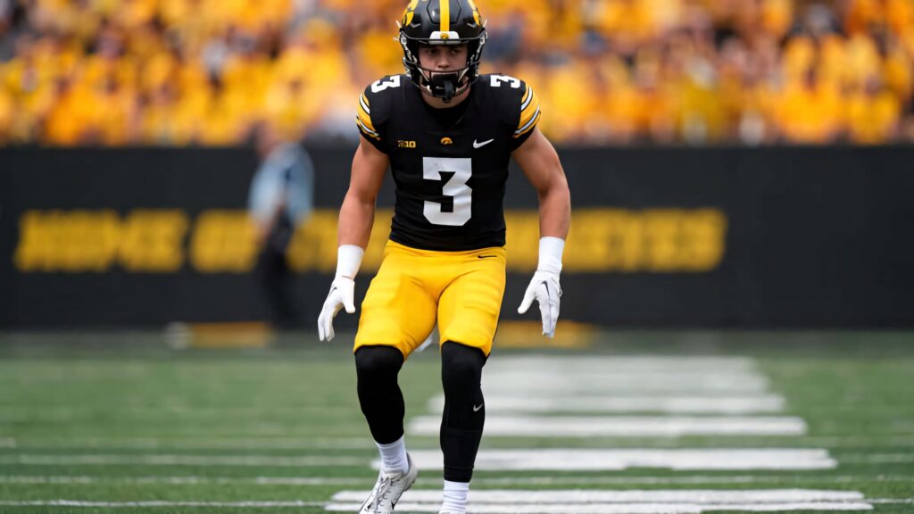 Cooper DeJean Iowa Hawkeyes number 3 in game-ready pose on vibrant gold black football wallpaper