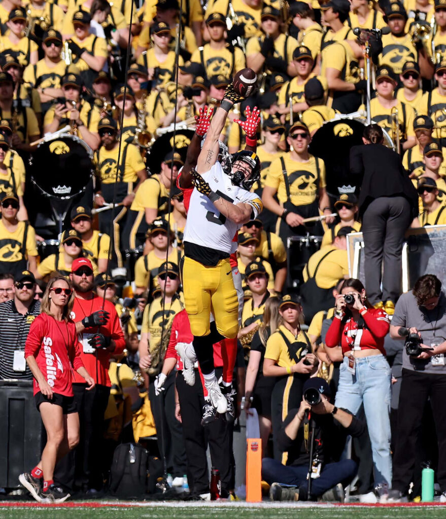 Cooper DeJean leaping mid-air intercepting pass with vibrant yellow black crowd background wallpaper