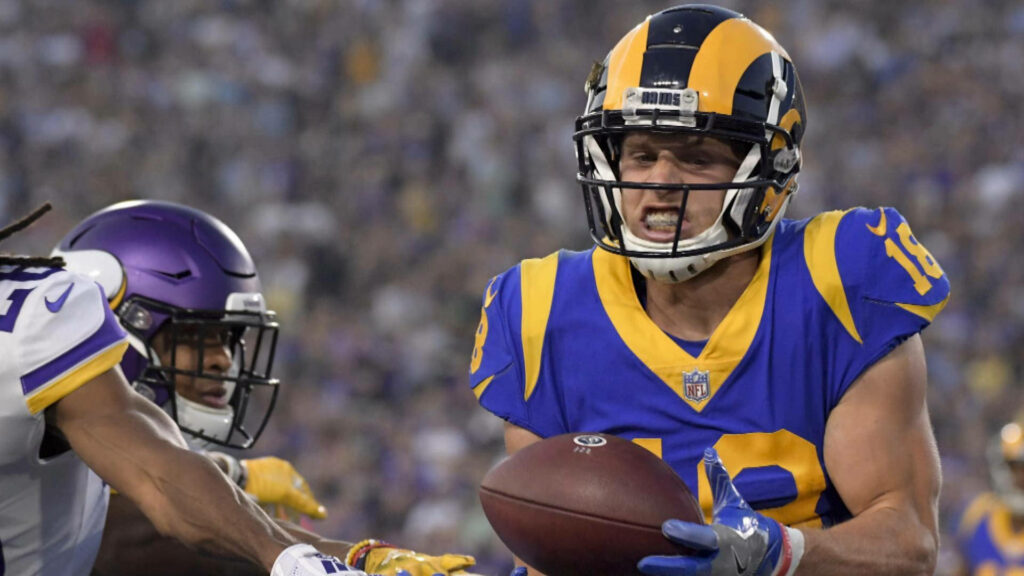Cooper Kupp of Rams makes a focused catch as NFL defenders close in during intense game play Wallpaper
