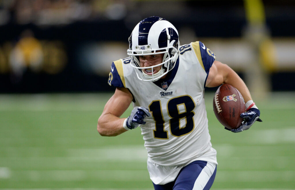 Cooper Kupp running with football in Los Angeles Rams uniform showing athletic focus on field Wallpaper
