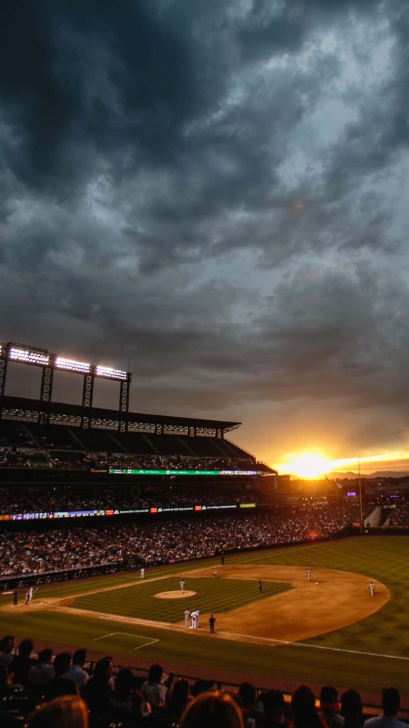 Coors Field baseball stadium at sunset with stormy clouds and illuminated floodlights wallpaper